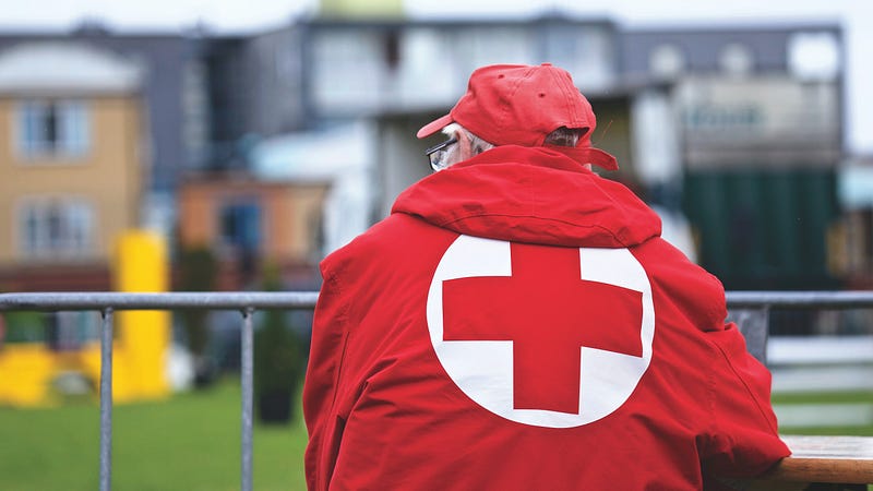 man standing in red ‘Red Cross’ jacket