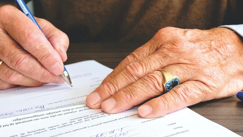 man signing a law document